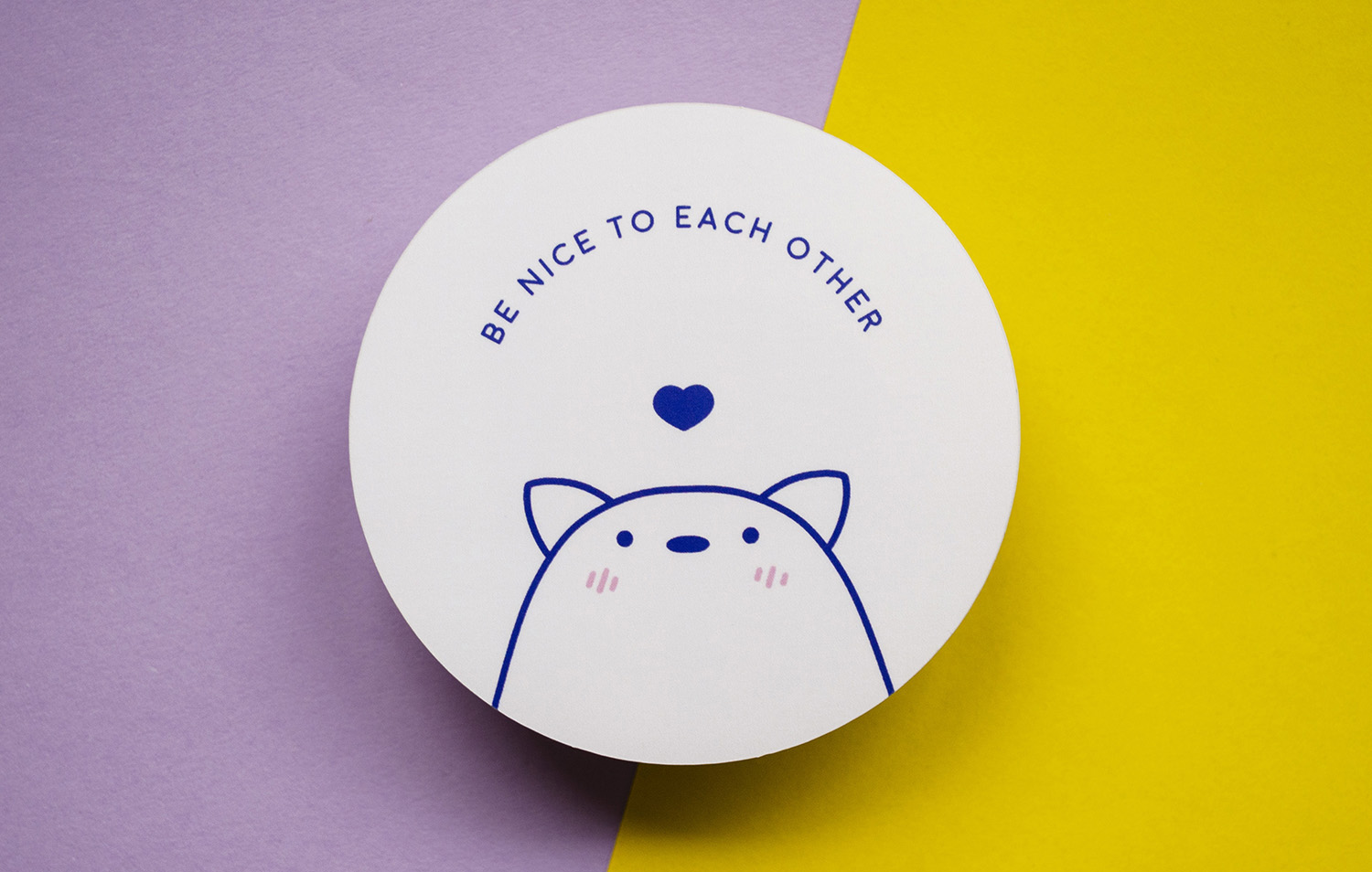 Round sticker with an animal and Be nice to each other als text on it